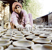 A potter in Jammu gives final touches to clay lamps ahead of Diwali.