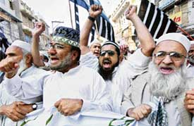 Islamists from the Jamiat Ulema-i-Islam shout slogans as they march against a military operation in the Swat valley in Peshawar on Friday.