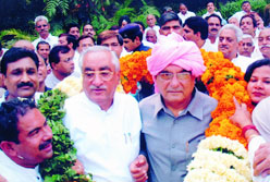 Haryana Chief Minister Bhupinder Singh Hooda being honoured by urban local bodies minister A.C Chaudhary for waiving house and chulha taxes in the Capital