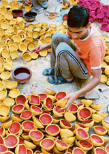 A boy gives final touches to earthen lamps for Divali in Amritsar. 
