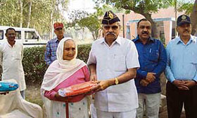 Brig R.K. Singh Gulia, president of the Haryana Ex-Services League, honours a war widow at a function in Kaithal on Sunday.