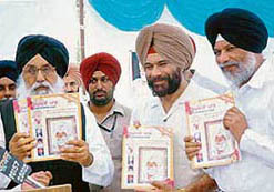 Chief Minister Parkash Singh Badal releases a souvenir on the 11th death anniversary of Jathedar Kartar Singh at Rakhra village, near Patiala, on Sunday.