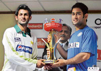 Indian skipper Mahendra Singh Dhoni and his Pakistani counterpart Shoaib Malik (L) pose with the trophy during a news conference in Guwahati.