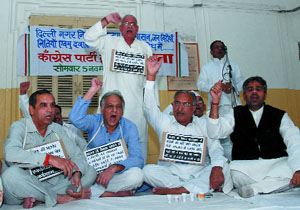 Congress municipal councillors stage a dharna at the main gate of Town Hall against the BJP-administered MCD in the Capital on Monday.