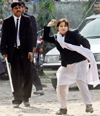A Pakistani woman lawyer throws stone towards police during a protest in Lahore on Monday.