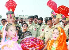 Students and principal of Shri Ram Ashram Public School present sweets to Pakistan rangers at the Wagah Border in Amritsar.