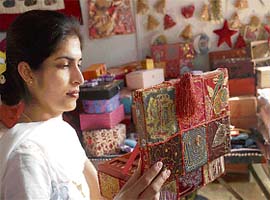Gurjeet Kaur displays an embellished bag at her stall in the mela