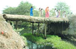 Villagers cross the Hudiara drain through a girder bridge at Hoshiar Nagar in Amritsar.