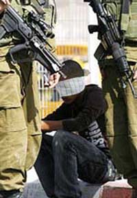 sraeli soldiers stand guard beside a blindfolded Palestinian youth at the Hawara checkpoint near the West Bank city of Nablus on Saturday. The youth was detained and sent for interrogation after he was caught carrying four explosive devices. 