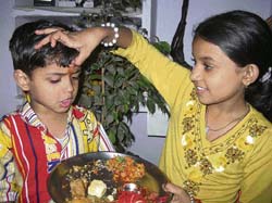 A girl applies tilak on her brothers forehead on the occasion of Bhaiya Dooj in Karnal on Sunday. 