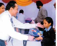 Chief general manager of State Bank of India Gautam Kanlilal hands over a kit containing winter school uniform and shoes to an adopted girl child on the occasion of Childrens Day at a funtion in the Capital on Wednesday.
