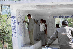 PWD workers erase BSP slogans from a rain shelter on the Palampur-Dharamsala road