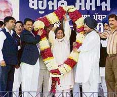 President of the BSP and Chief Minister of Uttar Pradesh Mayawati being garlanded by Avtar Singh Kareempuri (right), president of the Punjab unit of the party.