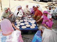 Women do sewa at a community kitchen.