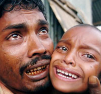 Bangladeshi cyclone-affected man Khalilur Rahman, who lost 11 members of his family, cries holding his only surviving daughter while waiting to get relief in Fokirghat, on the southern coastal area of Bangladesh, on Tuesday.