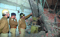 Fire department offcials on Wednesday guide rescue operation at the rubber factory which collapsed in the industrial area of Anand Pravat in the Capital
