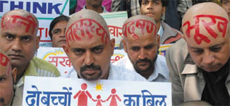 Members of the Surabhi Pariwar tonsured their heads and sat on a dharna, demanding a legislation to enforce the two-child norm, in the Capital on Friday.