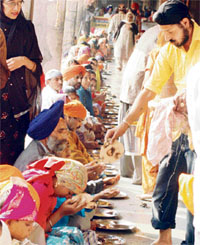 Devotees partake of langar on the occasion of Parkash Utsav of Guru Nanak Dev in Ludhiana on Saturday.