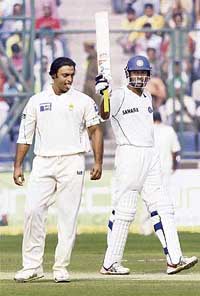 Wasim Jaffer acknowledges the crowd on completing his fifty as Pakistans Shoaib Akhtar looks on during the Delhi Test. 