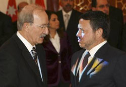 Jordans King Abdullah talks with his new Prime Minister Nader Dahabi during the swearing-in ceremony in Amman on Sunday.
