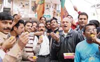 BJP workers distribute sweets at Hamirpur on Monday to celebrate the declaration of former Chief Minister Prem Kumar Dhumal as the BJPs chief ministerial candidate. 