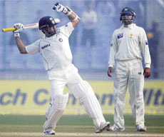 Sachin Tendulkar celebrates as Faisal Iqbal watches after India won the first Test against Pakistan in New Delhi on Monday.