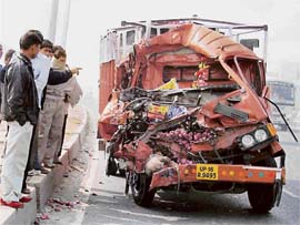 People look at a truck damaged in a collision with another one near the Hero Honda crossing on National Highway No. 8 in Gurgaon on Tuesday. The driver of the truck died on the spot.