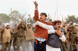 Indri MLA Rakesh Kambojs bodyguard tries to protect him during a lathicharge by the police in Karnal on Saturday.