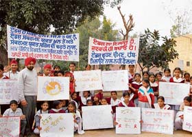 Students of the Doraha College of Education carry banners and shout anti-AIDS slogans at Kaddon village