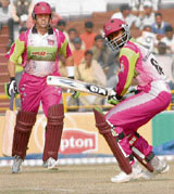 Chennai Superstars Russel Arnold plays a shot as captain Stuart Law looks on during their Twenty20 match against Kolkata Tigers at the Tau Devi Lal Cricket Stadium in Panchkula on Saturday.