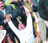 A protester who disrupted the celebrations of World Disability Day being carried away by policemen at the India Gate in the Capital