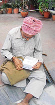 Ram Swaroop, a 60-year-old handicapped resident of Galian village, outside the bank branch in futile wait for his pension.