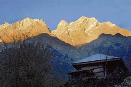 The jagged Kinner Kailash peaks glow in the orange hues of the sun