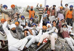 Farmers from the border area protest at the railway track at Manewala railway station, near Amritsar