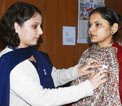 Capt Isha Thakur, deputy director, Army welfare, tags a flag on Hamirpur DC Nandita Guptas shoulder to commemorate Army Flag Day on Friday.