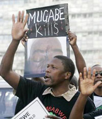 A demonstrator holds up a poster during a protest against Zimbabwes President Robert Mugabe during the EU-Africa summit in Lisbon on Saturday.