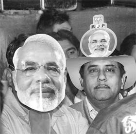 A supporter of the Gujarat Chief Minister wears his mask at an election rally in Ahmedabad