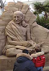 Boys view a sand sculpture of Mahatma Gandhi during an annual sand sculpture event in the northeast Italian town of Jesolo on Saturday.