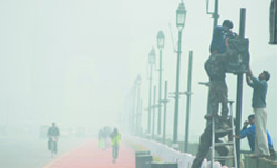 As mercury dips, fog engulfs Capital. A cyclist pedals through fog on Raj Path in the Capital