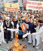 Workers of the Haryana Janhit Congress (BL) burn an effigy of the district administration in Karnal