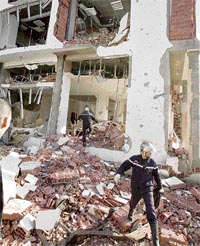 Rescue workers stand outside the Constitutional Court building after a bomb blast in Algiers on Tuesday.