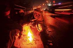 A cold winter night appears to be a colourful canvass on Jagraon bridge as this Tribune lensman captures a man’s effort to keep cold at bay by lighting a campfire on Tuesday night.