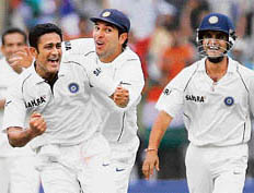 Anil Kumble (2L), Yuvraj Singh (C) and Sourav Ganguly (R) celebrate the dismissal of unseen Pakistani cricketer Kamran Akmal during the fifth day of the third Test match between India and Pakistan at the Chinnaswamy Stadium in Bangalore on Wednesday.