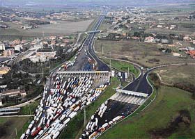 An aerial view of trucks blocking a highway toll booth during a transport strike on the outskirts of Rome