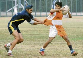 A Punjab rugby player holds a Maharashtra opponent by his shirt during a semifinal match at PU grounds, Chandigarh