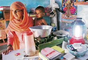 A woman uses a solar lamp in a hamlet in the Morni hills.