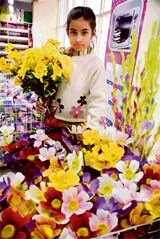 FLOWER GIRL: A small girl chooses flowers during the inauguration of a chain mall in Jammu. 