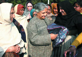 Chief Minister Sheila Dikshit gives blankets to poor women at her residence in the Capital on Sunday. 