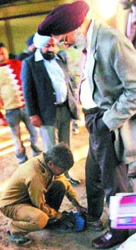 A peon cleans the shoe of principal secretary DS Guru during the inspection of solid waste management plant in Jalandhar. 
