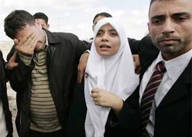 A Palestinian Hamas prisoner (centre), who was released after spending 28 months in an Israeli jail, walks with her husband (right) and brother at Erez crossing in Gaza
